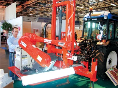 Robotic apple picker mounted on a tractor using machine vision for automated fruit harvesting.