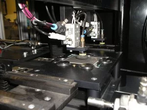 Vision system inspecting surface mounted resistors for defects like blemishes, cracks, and scratches during production.