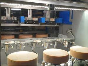 Cameras in a blue housing capture images of cheese wheels inside the care robot