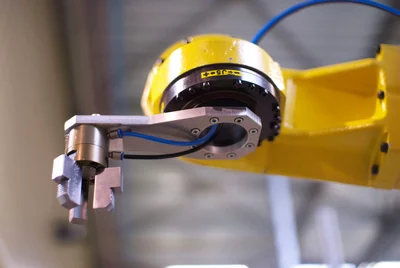 Robot arm in a flexible manufacturing cell used for automotive parts inspection and assembly with vision-guided system.