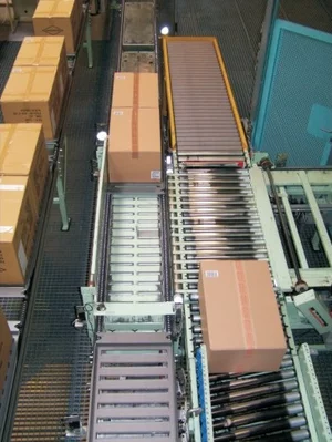 Packages transferred onto a metal tray carrying a TID barcode for warehouse identification.