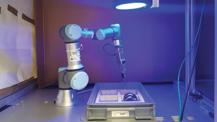 Pick-and-place robot cell with controlled illumination for reliable machine vision–based implant recognition.
