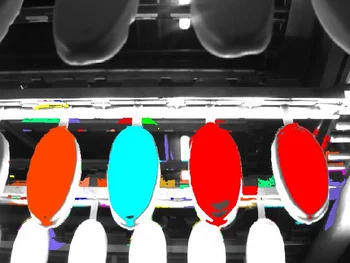 Ice creams on a production line inspected by a machine vision system before processing.