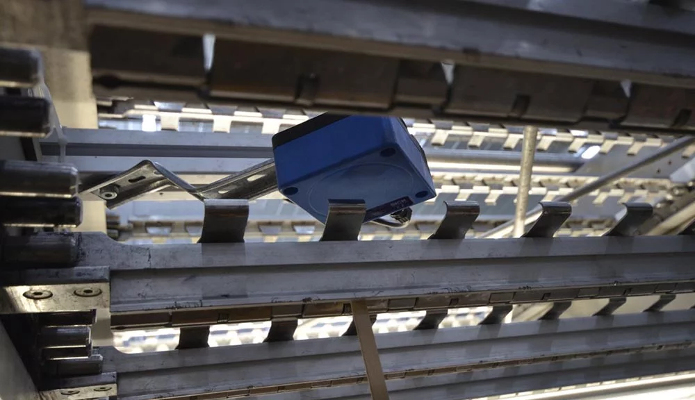 Inductive sensor integrated into an ice cream production line for position detection and triggering.