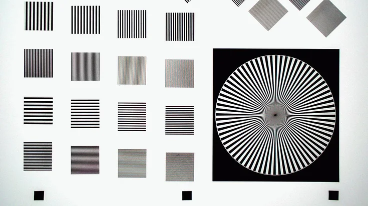 Camera test chart with line patterns and a Siemens star used for measuring resolution, contrast, and optical performance.