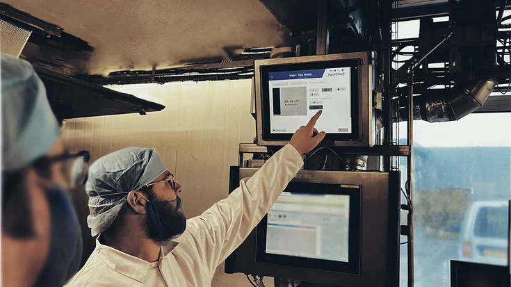 Operating personnel using the PackCheck machine vision solution for quality control in food packaging production.