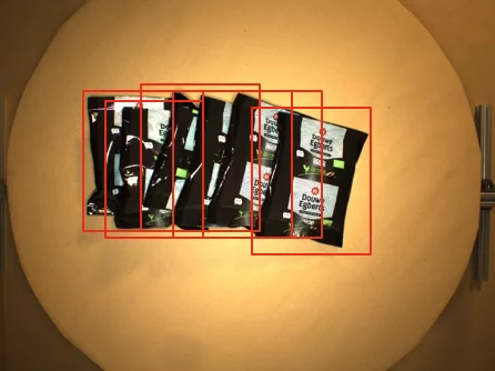 The image shows the result of object detection, in which coffee packages were correctly detected using deep learning and enclosed by bounding boxes.