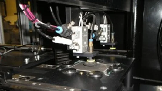 Vision system inspecting surface mounted resistors for defects like blemishes, cracks, and scratches during production.