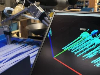 Bin picking application using machine vision to locate and grip medical catheters in random orientations for automated packaging.