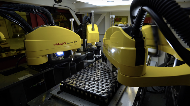Industrial robots performing laser welding on battery cells guided by machine vision.