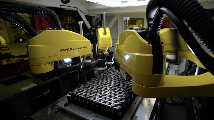 Industrial robots performing laser welding on battery cells guided by machine vision.