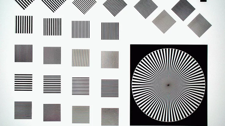 Camera test chart with line patterns and a Siemens star used for measuring resolution, contrast, and optical performance.