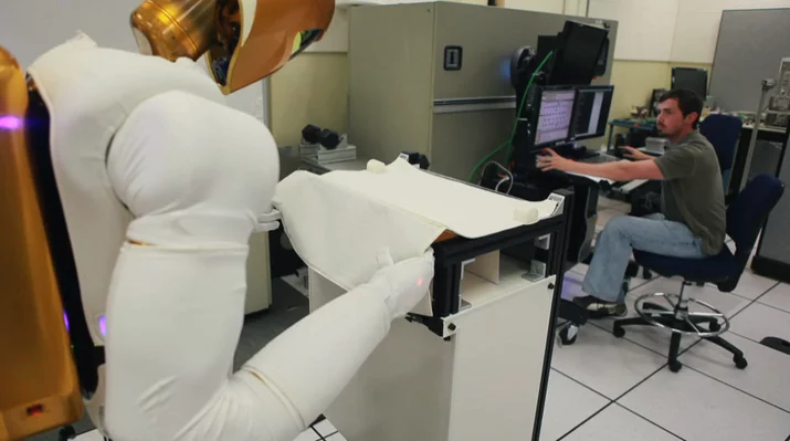 Robonaut R2 being tested in a laboratory environment using stereo vision and TOF data for precise object handling.