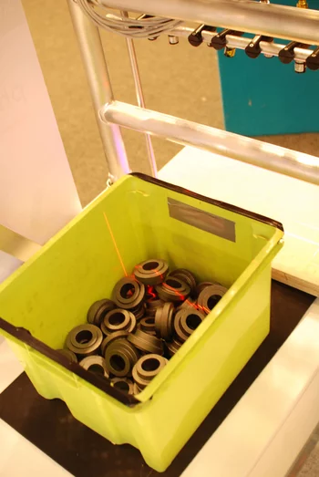 Box with raw metal parts for manufacturing, scanned by machine vision for sorting and inspection.