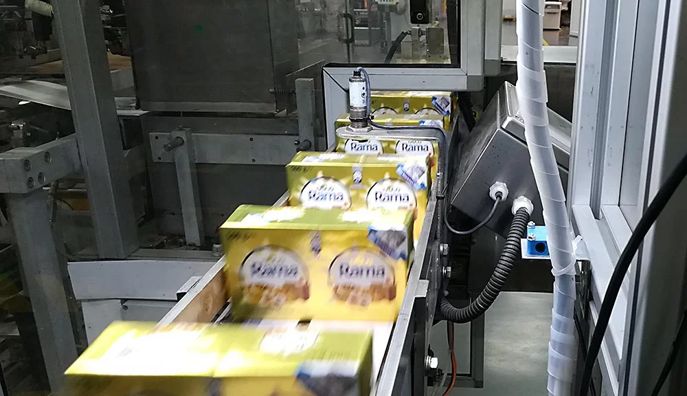 Margarine packages transported on a conveyor system during food production.