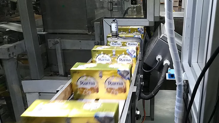 Margarine packages transported on a conveyor system during food production.