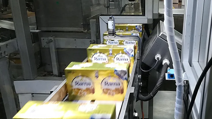 Margarine packages transported on a conveyor system during food production.